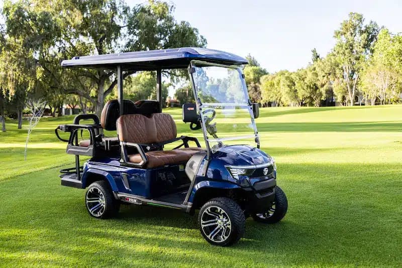Zycar E4 azul de 4 pasajeros en campo de golf, vista frontal lateral